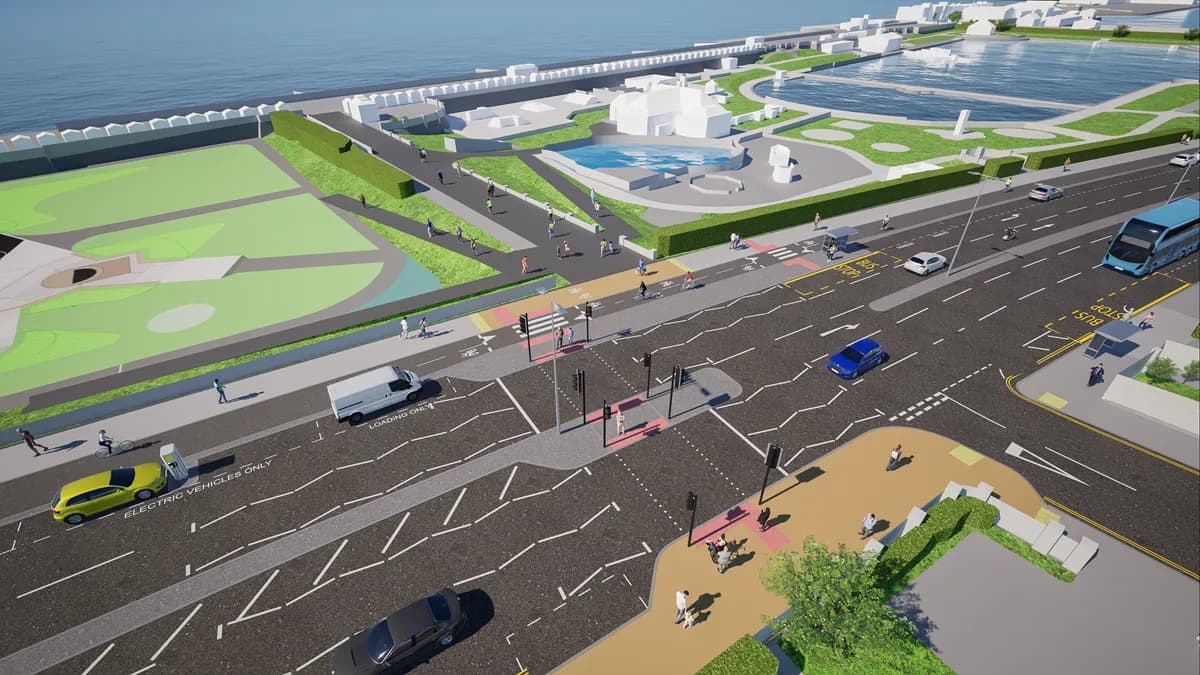 An aerial render of a coastal city with a road running parallel to a green park area and the ocean, featuring various cars, buses, and pedestrians, with several buildings and a water feature in the background.