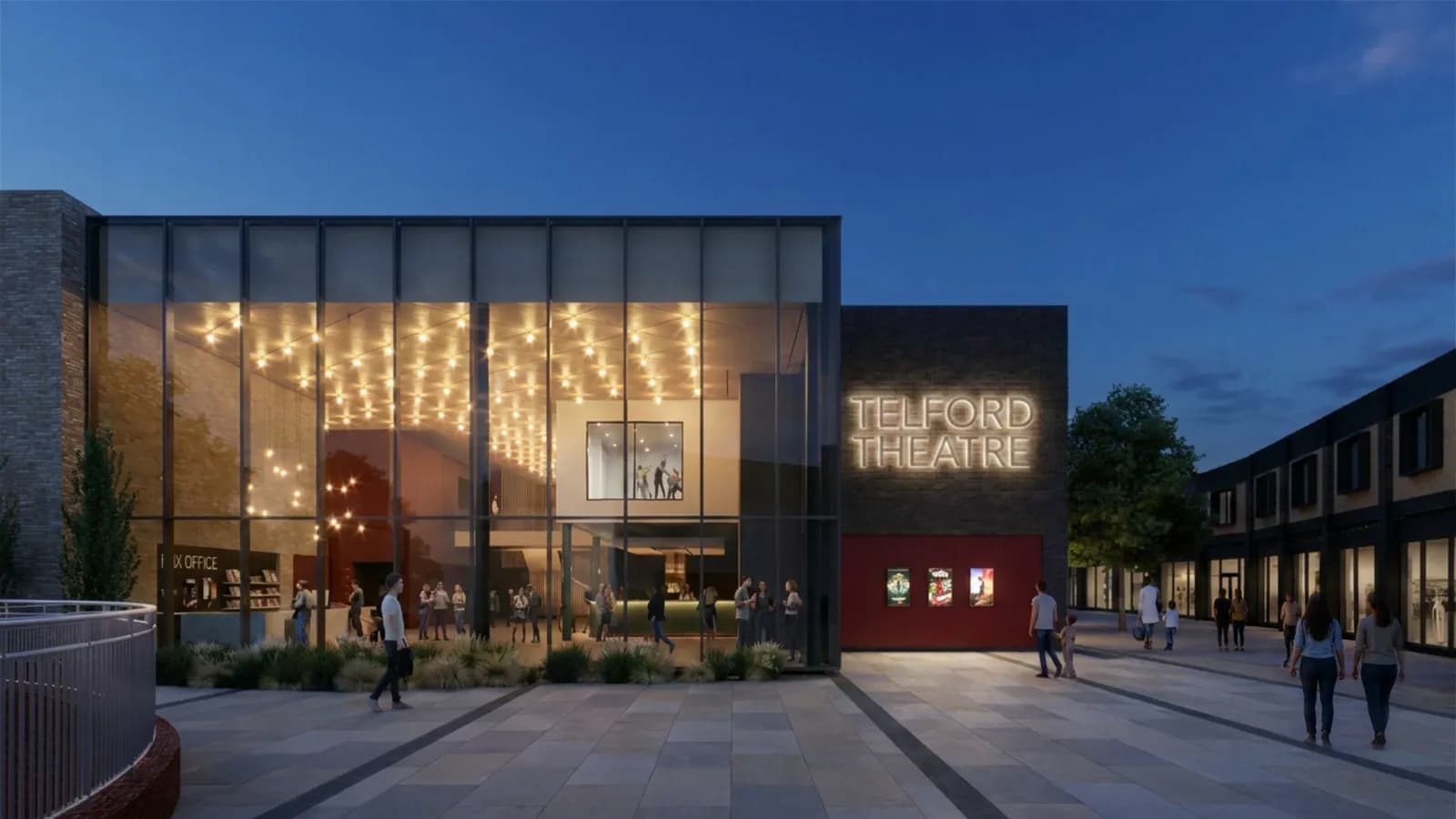 An evening view of the Telford Theatre building with a brightly lit glass facade and people gathered inside and walking on the paved area outside.