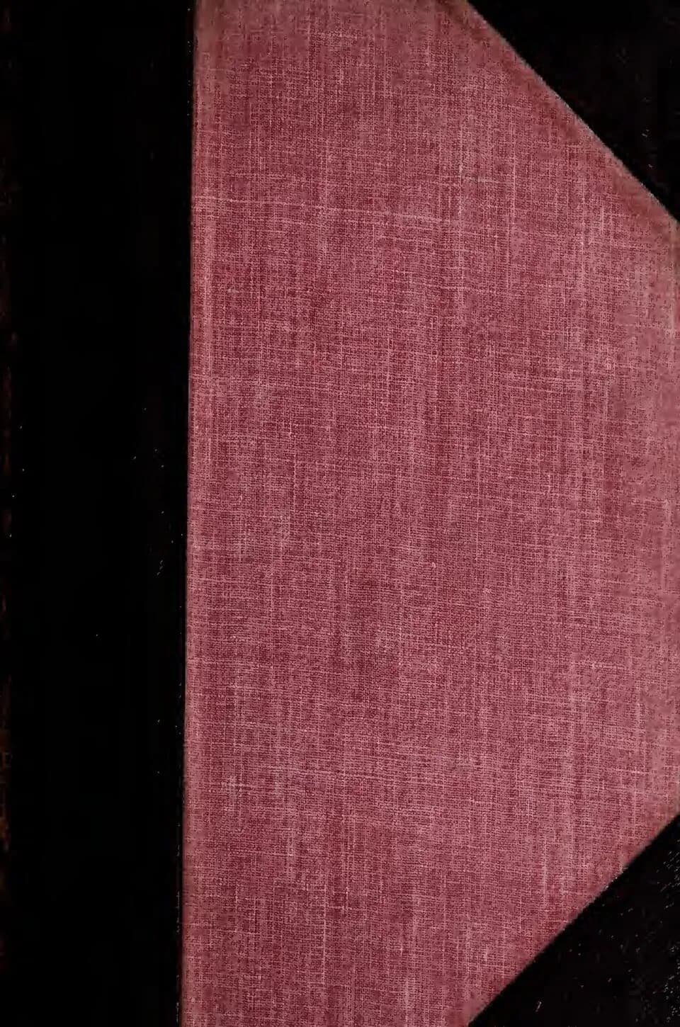 A close-up view of a book cover with a deep red fabric texture on the right and a dark black spine on the left, with some additional black areas visible at the top and bottom right corners.