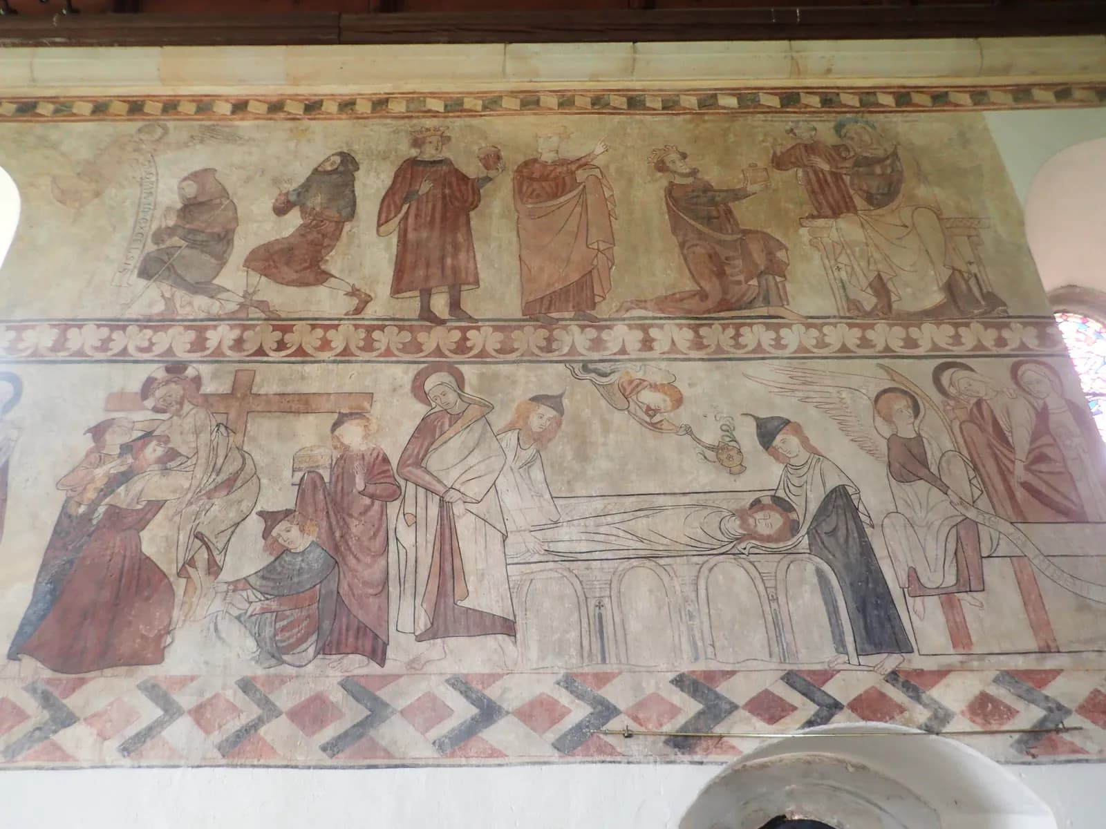 A detailed ancient fresco depicts multiple religious scenes with figures dressed in robes and crowns, some appearing to be in motion or engaged in interactions.
