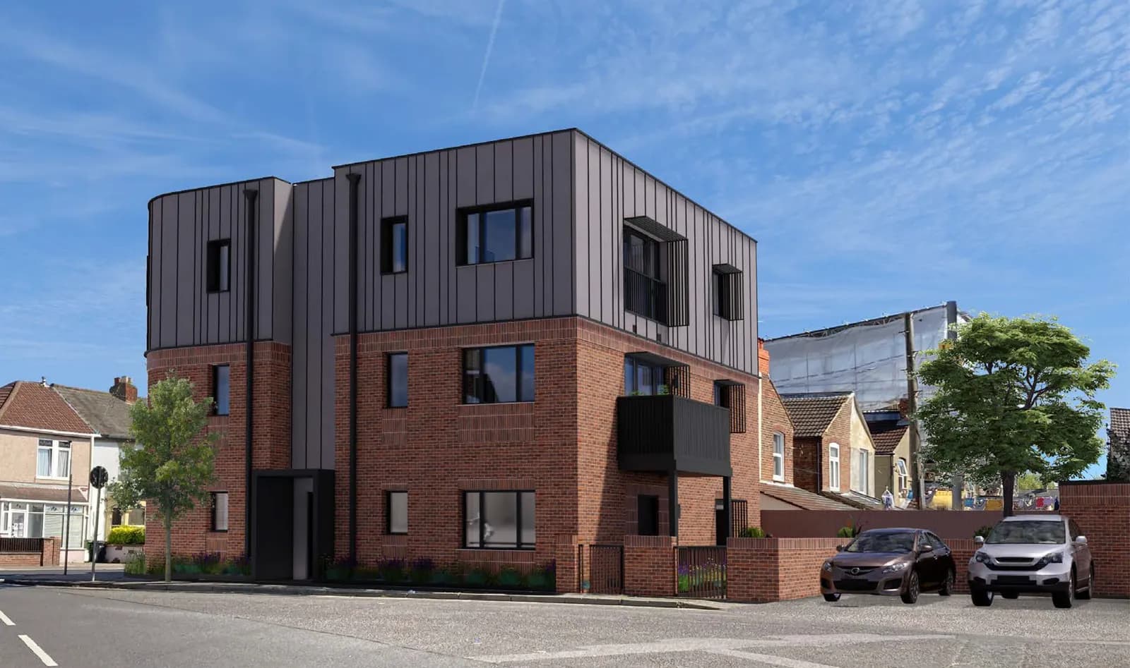 A modern building with a brick ground floor and a dark grey metal paneled upper floor, featuring multiple windows and a small balcony, situated next to a street with cars parked nearby.