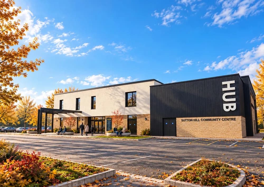 A modern community centre building with a white facade and a black section featuring the words "HUB" and "SUTTON HILL COMMUNITY CENTRE" on a sunny day in autumn, with people entering the building and trees with colorful foliage.