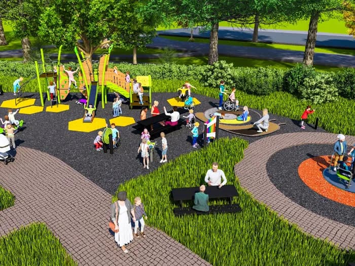 An overhead view of a diverse group of children and adults enjoying an inclusive playground with various accessible equipment, surrounded by green grass and trees.