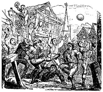 A chaotic scene of a large group of men playing an early version of football or soccer in a village street, with one man on scaffolding watching from above, and a church steeple in the background.